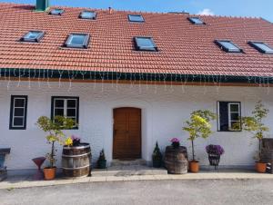 ein weißes Haus mit einem roten Dach und einer Tür in der Unterkunft Ferienwohnungen Bonnleiten Familie Stöger in Stössing