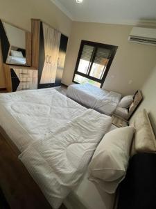 een groot wit bed in een slaapkamer met een raam bij القاهره حلوان تقسيم سلاح المهندسين شارع الجبل in Sheikh Zayed