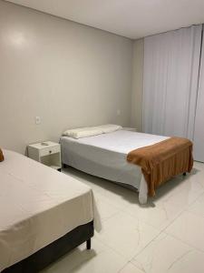 1 dormitorio con 2 camas y suelo blanco en CASA 11 - Condomínio Lençóis Park Barreirinhas, en Barreirinhas