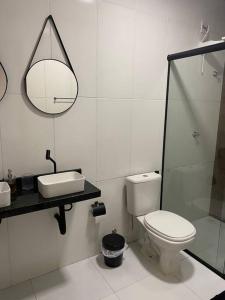 a bathroom with a toilet and a sink and a mirror at CASA 11 - Condomínio Lençóis Park Barreirinhas in Barreirinhas
