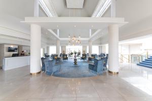 un gran vestíbulo con sillas azules y un bar en Portmarnock Resort & Jameson Golf Links, en Portmarnock
