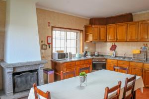 eine Küche mit einem Tisch und einem Kamin in der Unterkunft Martins House Quartos in Arouca