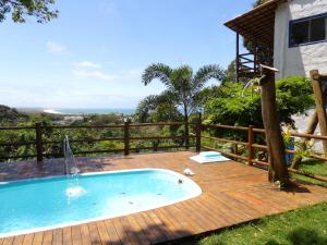 a swimming pool on a wooden deck next to a house at Vila Boa Vista Itacaré in Itacaré