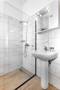 a white bathroom with a sink and a shower at Anixis Hotel & Apartments in Ialysos