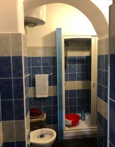 bagno piastrellato blu con lavandino e servizi igienici di Loft Accogliente - Piazza San Giovanni a Roma