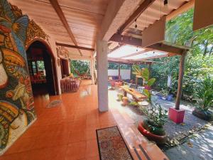 una gran sala de estar con un patio con mesas y sillas. en Macondo Hostel, en Isla Grande