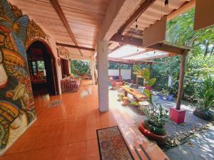 a large living room with a patio with tables and chairs at Macondo Hostel in Isla Grande