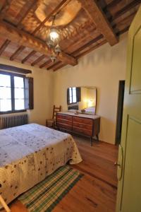 Schlafzimmer mit einem Bett, einer Kommode und einem Spiegel in der Unterkunft Casetta del Pozzo in Seggiano
