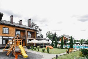un complejo con un tobogán y un parque infantil en Zagorod Hotel en Girka Polonka