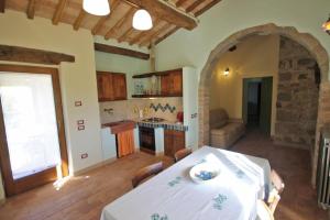 eine Küche mit einem weißen Tisch im Zimmer in der Unterkunft Casetta del Pozzo in Seggiano