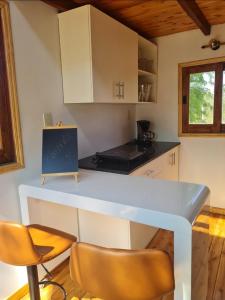 a kitchen with a counter and chairs in a room at Haasienda - Nido del Loro - Casa de Arbol 