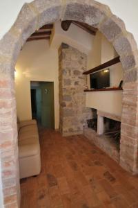 einen Torbogen in einem Wohnzimmer mit einem Steinkamin in der Unterkunft Casetta del Pozzo in Seggiano