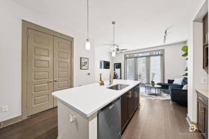a kitchen with a sink and a large open door at Downtown Houston Deluxe King Suite with Spa Amenities, Pool and Free Parking in Houston