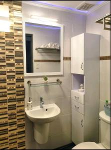 a white bathroom with a sink and a mirror at CityCondo, 2nd Fl, 30 sqm, near CPU, balcony and parkview, Netflix, free parking in Iloilo City