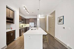 a kitchen with a white counter top and wooden cabinets at Downtown Houston Deluxe King Suite with Spa Amenities, Pool and Free Parking in Houston