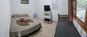 een slaapkamer met een bed en een tv in een kamer bij Pousada Sol e Mar in Ilha do Mel