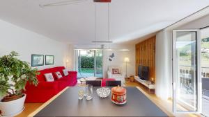 ein Wohnzimmer mit einem roten Sofa und einem Tisch in der Unterkunft Ferienwohnung für 5 Personen Piz Linard Lantsch-Lenzerheide in Lenz
