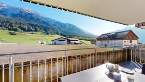 einen Balkon mit Blick auf ein Feld und die Berge in der Unterkunft Ferienwohnung für 5 Personen Piz Linard Lantsch-Lenzerheide in Lenz