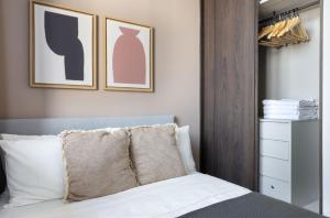 a bedroom with a bed with two pictures on the wall at Sunny 1BR / 1Bath apartment in Singapore! in Singapore