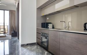 a kitchen with a counter and a sink and a stove at Sunny 1BR / 1Bath apartment in Singapore! in Singapore