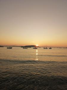 um pôr do sol sobre o oceano com barcos na água em Casa di Sole Ischia em Ischia