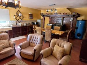 a living room with chairs and a table and a kitchen at Casa do Corgo in Ermida