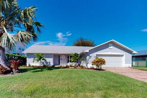 uma casa branca com uma palmeira num quintal em Morning Glory em Cape Coral