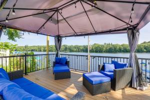 a deck with blue chairs and a view of the water at Riverfront New Hampshire Cottage with Boat Dock in Manchester