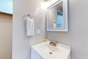 ein weißes Badezimmer mit einem Waschbecken und einem Spiegel in der Unterkunft Royal Blue Villa 2 in La Follette