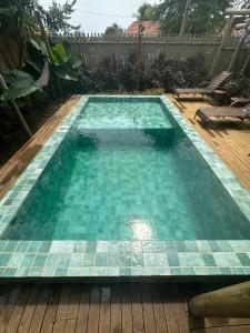 a swimming pool with blue tiles on a wooden deck at Pousada Ares de Noronha in Fernando de Noronha