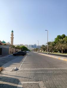 an empty street with a lighthouse in the distance at King bed-Studio Room Near "al bateen" Abudhabi in Abu Dhabi