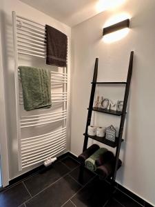 a bathroom with a towel rack and a shelf at Ferienwohnung Storchennest in Eisfeld