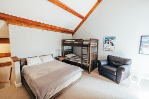 1 dormitorio con cama, silla y escritorio en Newly Renovated, Spacious Condo, 3 min to the ski lifts!, en Bethel