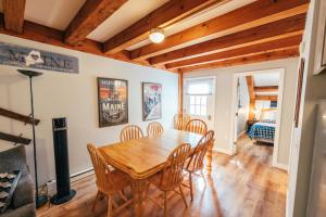 a dining room with a wooden table and chairs at Newly Renovated, Spacious Condo, 3 min to the ski lifts! in Bethel