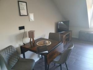 a room with a table and chairs and a television at Neumühler Hof- Ferienwohnung "Benjamin" mit großer Privater Dachterasse und guter Anbindung in die City in Schwerin