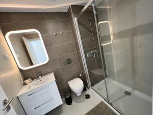 a bathroom with a shower and a toilet and a sink at Luxury flat with ocean view Nazaré Sitio in Nazaré +39 photos