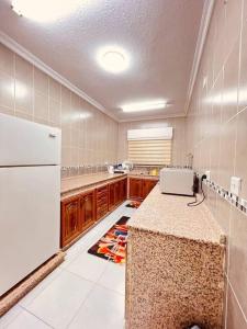 a kitchen with a counter and a white refrigerator at Lovely 3 bedrooms rental unit in Aqaba
