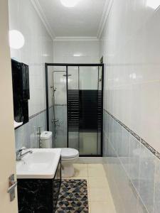 a bathroom with a shower and a toilet and a sink at Lovely 3 bedrooms rental unit in Aqaba