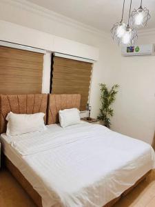 una camera da letto con un grande letto bianco con due cuscini di Lovely 3 bedrooms rental unit ad Aqaba