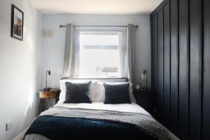 um quarto com uma cama grande e uma janela em A Lil cosy Belfast home em Belfast