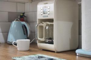 un microondas sentado en un mostrador de cocina junto a una taza en A Lil cosy Belfast home en Belfast