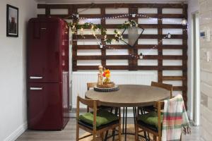 A Lil cosy Belfast home في بلفاست: غرفة طعام مع طاولة وثلاجة