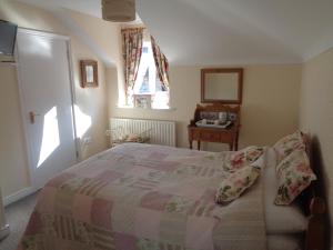 1 dormitorio con cama, mesa y ventana en Dromard House, en Enniskillen