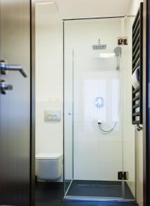 a glass shower with a toilet in a bathroom at Terminal Hotel in Wrocław