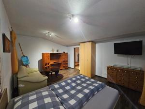 Sankt MargarethenにあるFerienhaus Schwalbeのベッドとソファとテレビのある寝室