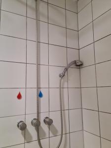 a shower in a white tiled bathroom at Jurerê Beach Village Studios Para Temporada in Florianópolis +29 photos