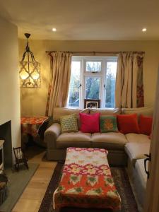 un salon avec un canapé et une fenêtre dans l'établissement St Anthony’s, bright perkily decorated 3 bedroom house, à Ampleforth