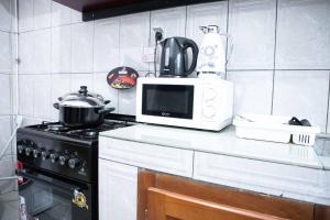 a kitchen counter with a microwave and a stove at Hypo Guest Lounge in Yaoundé