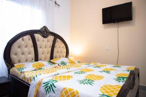 a bedroom with a bed with a pineapple bedspread at Hypo Guest Lounge in Yaoundé
