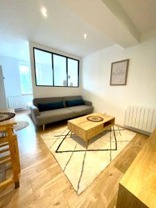 a living room with a couch and a coffee table at Appartement le Regnaudin in Moulins